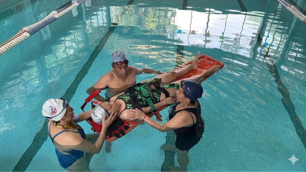 Participantes practican el uso de una tabla de rescate en una alberca.