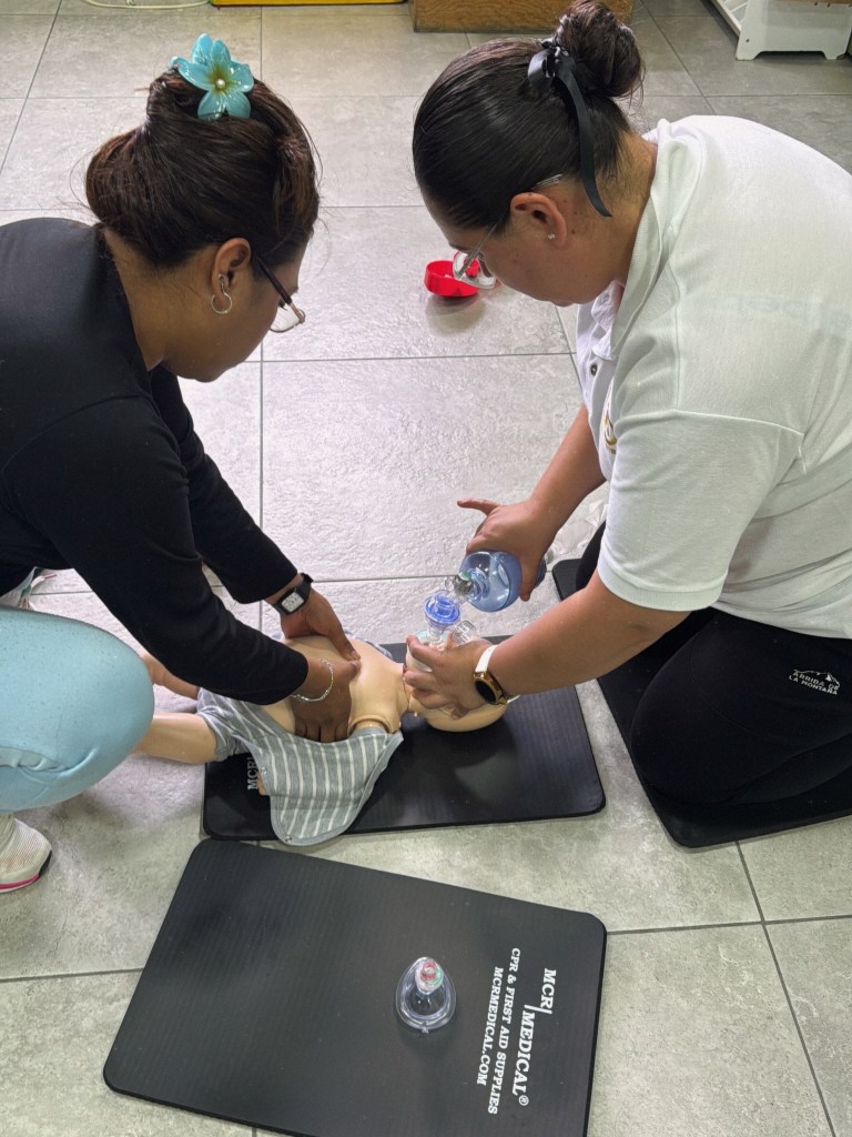 Práctica de RCP y ventilación con un maniquí pediátrico.