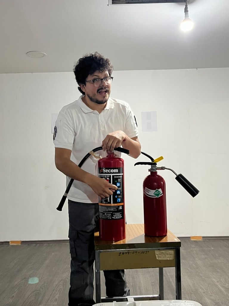 Instructor explica el uso de distintos tipos de extintores durante una capacitación.
